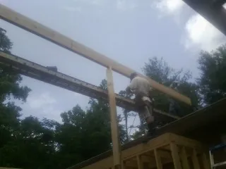 Carpenter setting a ridge beam over a new addition frame — Ice Dam Removal by Roofing Brothers in Pendleton